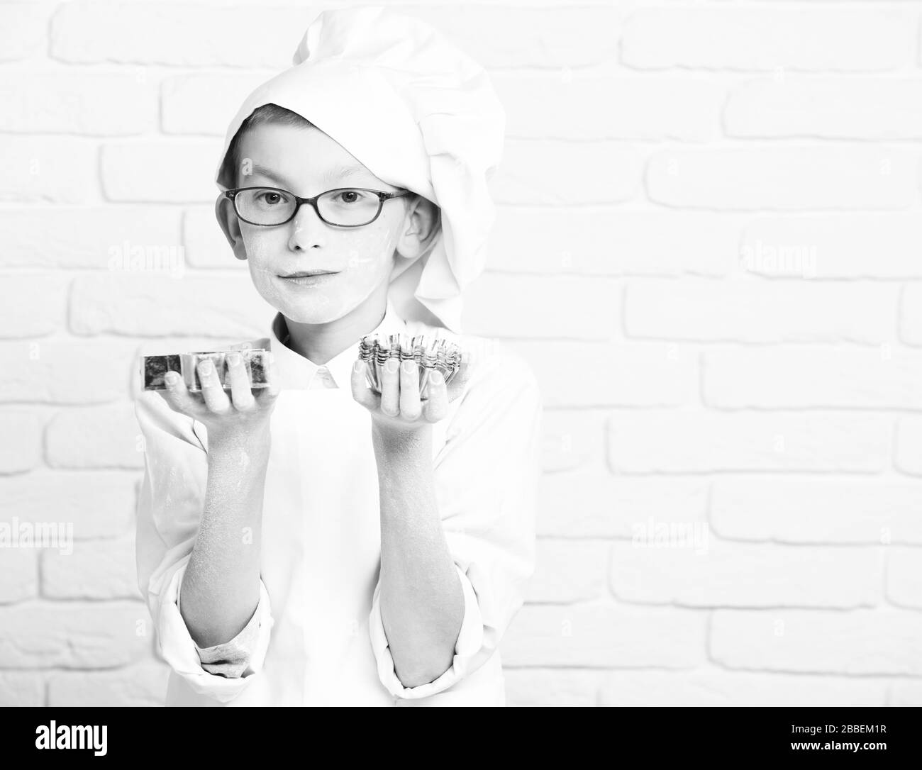 Junge kleine niedliche Koch Küchenchef in weiße Uniform und Mütze auf Flecken Gesicht Mehl mit Brille Holding 08/15 Sterne auf Mauer Hintergrund Kopie Raum Stockfoto