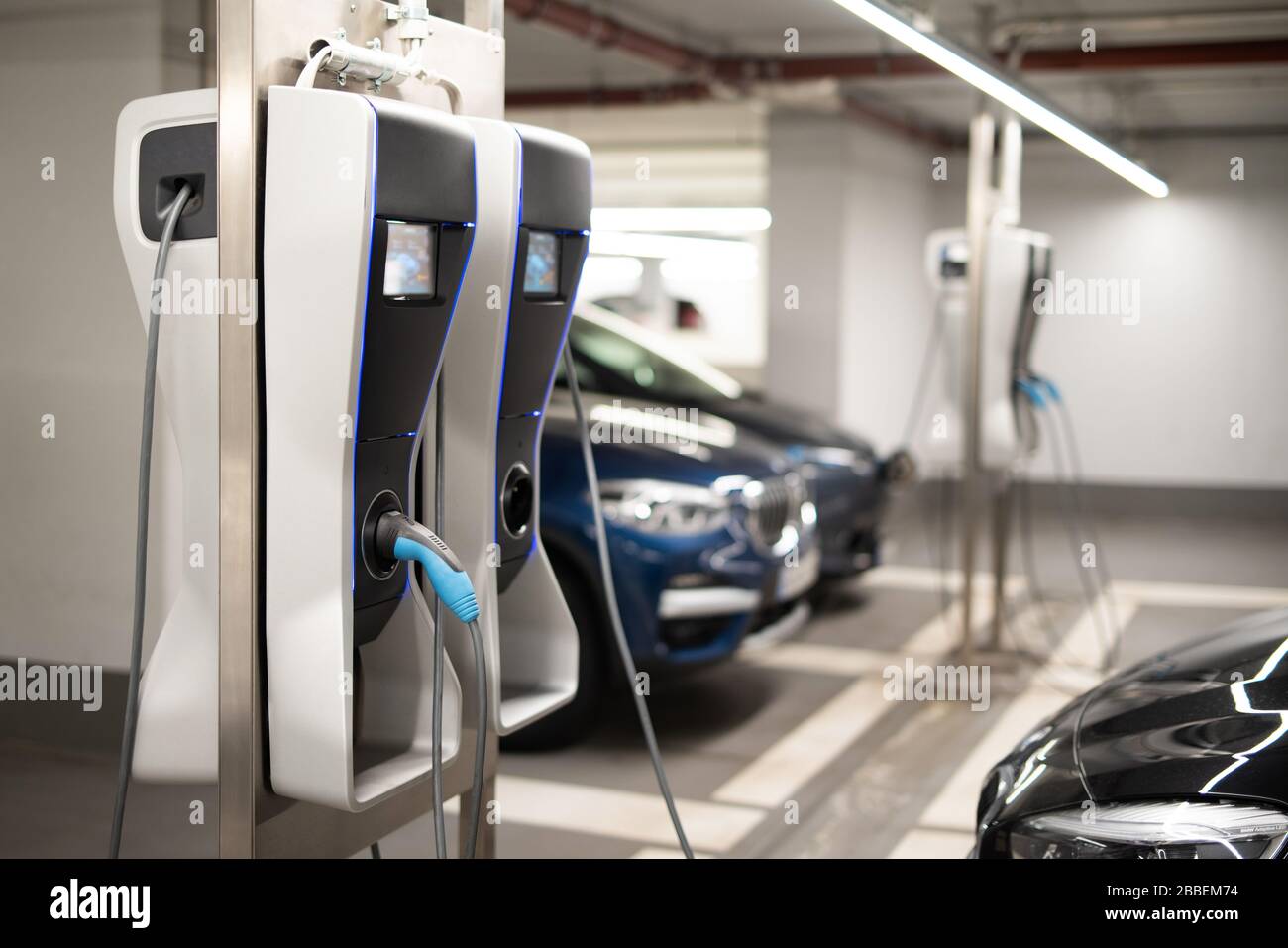 Elektroautos an einer Ladestation in einer Tiefgarage Stockfoto