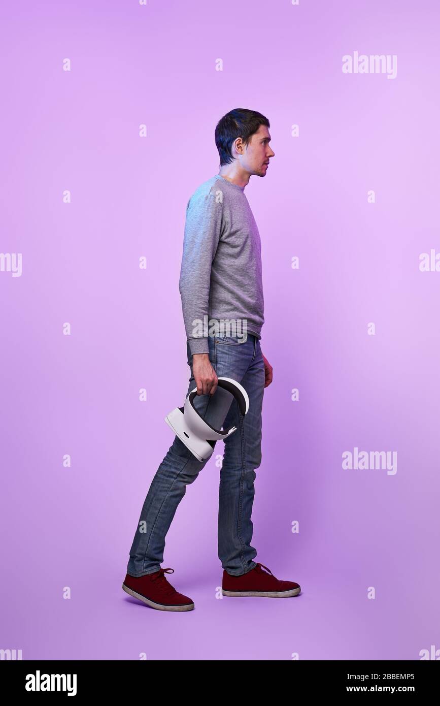 Mann mit Virtual-Reality-Headset in den Händen. Konzept der virtuellen Realität, Spiele, Unterhaltung und Kommunikation. Stockfoto