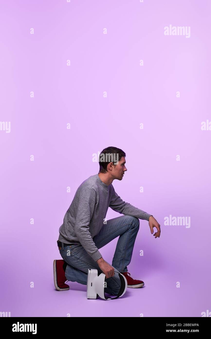Mann mit Virtual-Reality-Headset in den Händen. Konzept der virtuellen Realität, Spiele, Unterhaltung und Kommunikation. Stockfoto