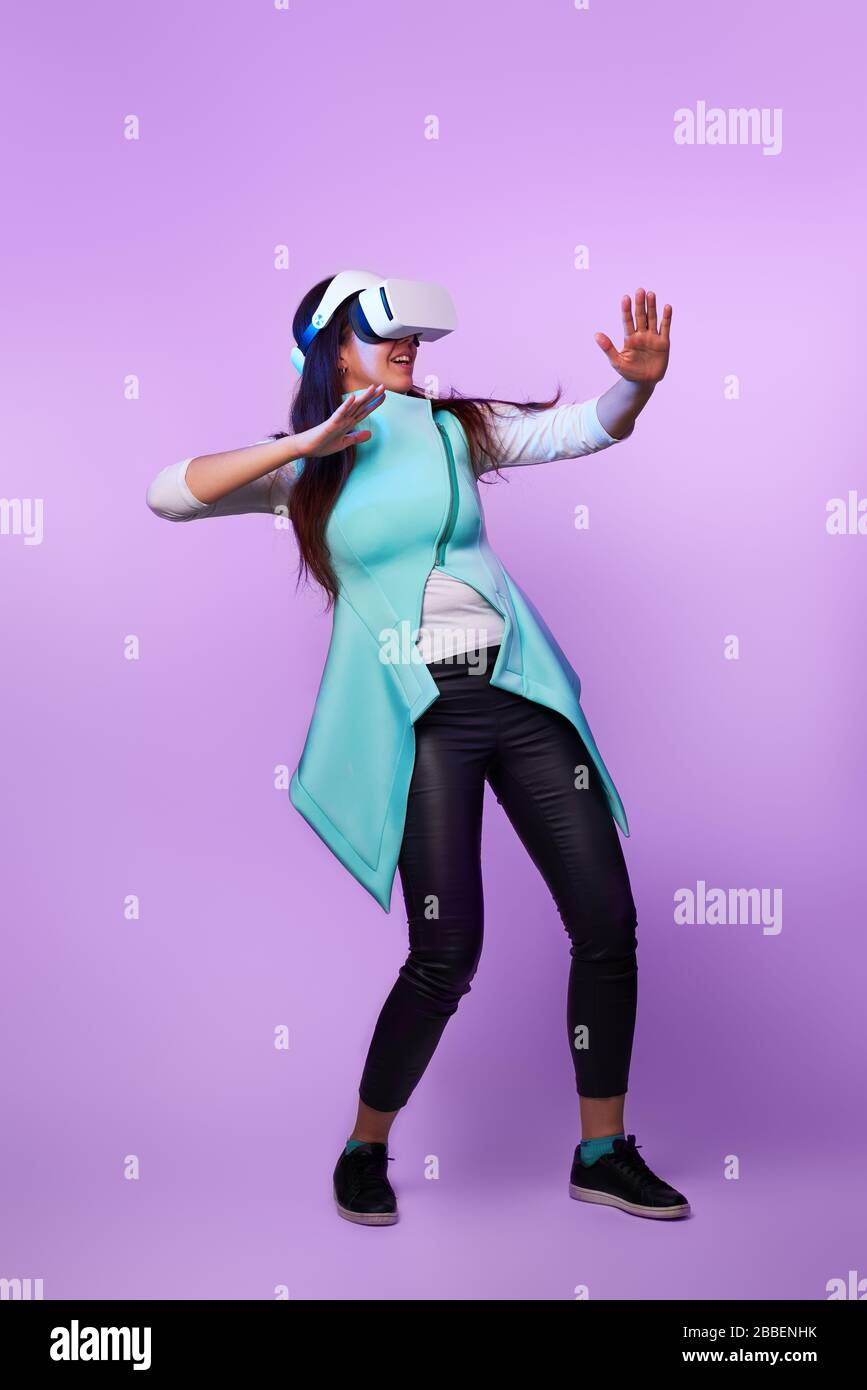 Frau mit Virtual reality Headset. Konzept der virtuellen Realität, Spiele, Unterhaltung und Kommunikation. Bild in der modernen Neon farbe Gamma. Stockfoto
