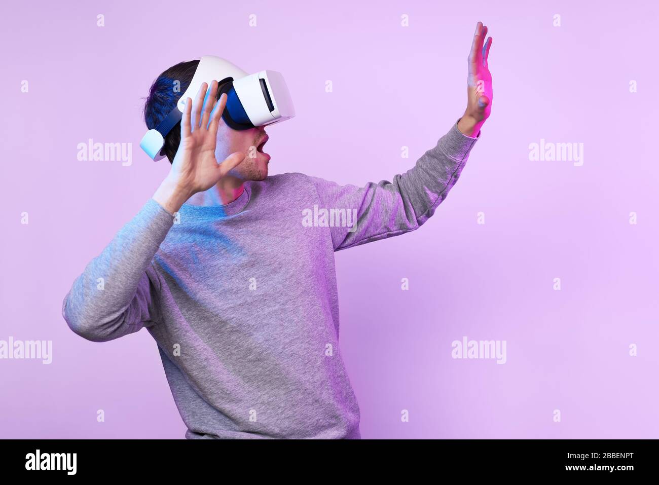 Mann mit Virtual reality Headset. Konzept der virtuellen Realität, Spiele, Unterhaltung und Kommunikation. Bild in der modernen Neon farbe Gamma Stockfoto