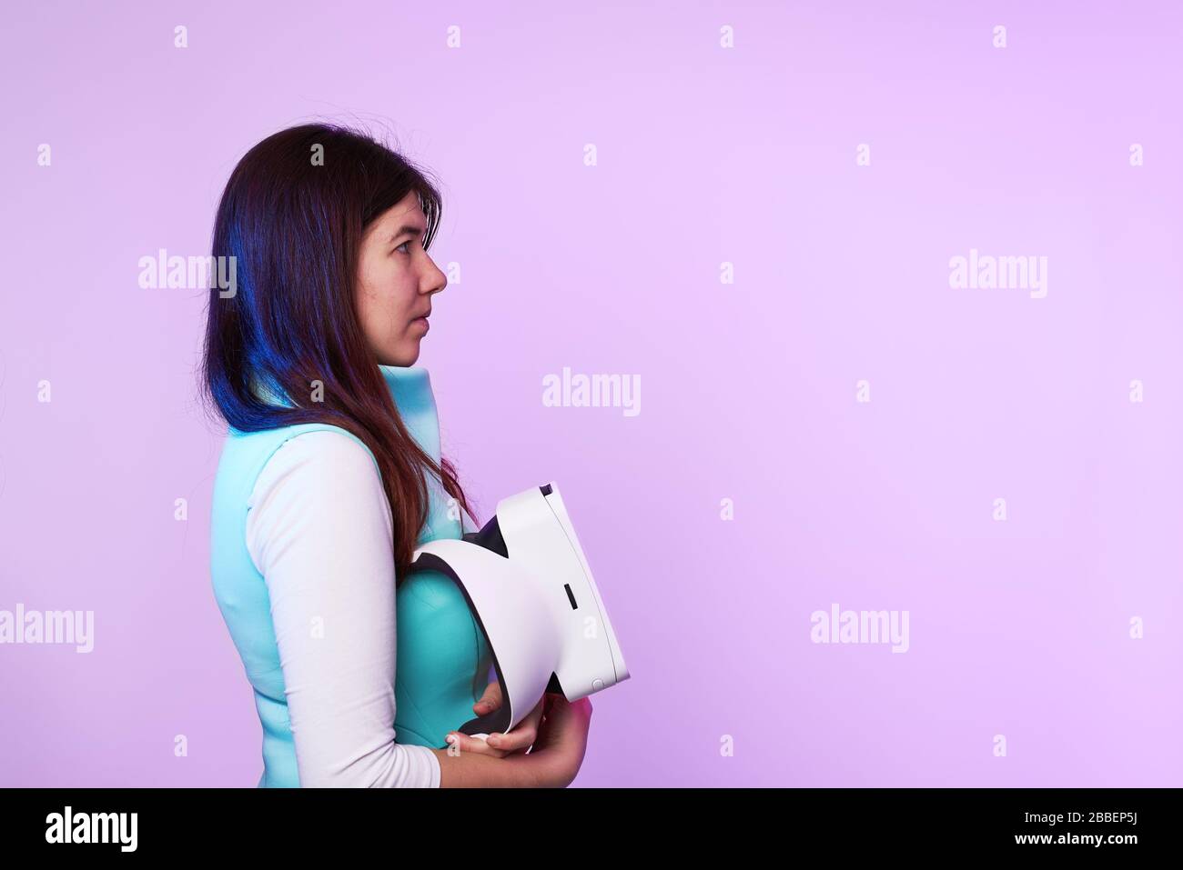 Frau mit Headset für virtuelle Realität in ihren Händen. Konzept der virtuellen Realität, Spiele, Unterhaltung und Kommunikation. Stockfoto