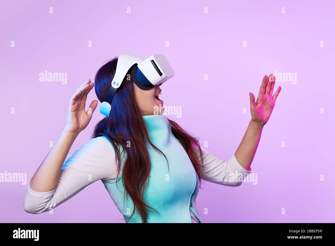 Frau mit Virtual reality Headset. Konzept der virtuellen Realität, Spiele, Unterhaltung und Kommunikation. Bild in der modernen Neon farbe Gamma. Stockfoto