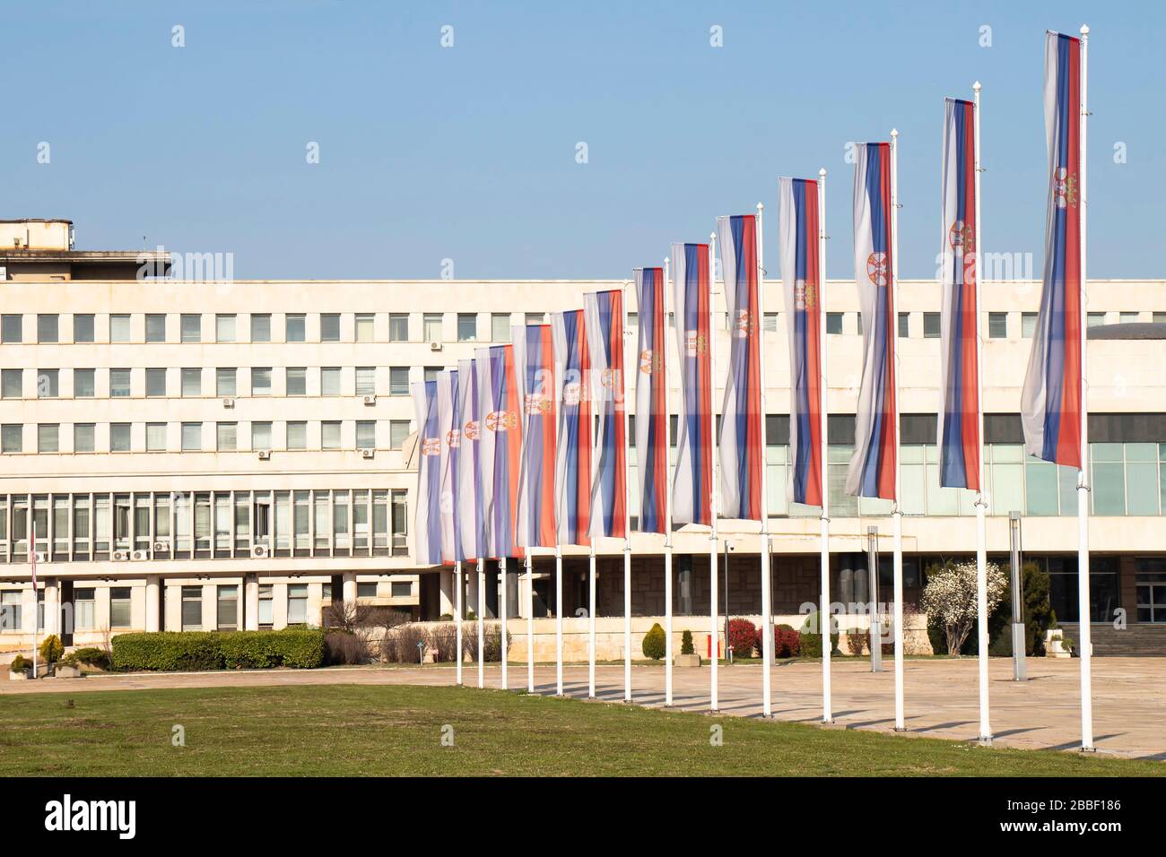 Belgrad, Serbien - 20. März 2020: Serbische Nationalflaggen auf Pfosten vor dem Palast Serbiens, Regierungsgebäude 1951 fertiggestellt, die LARG Stockfoto