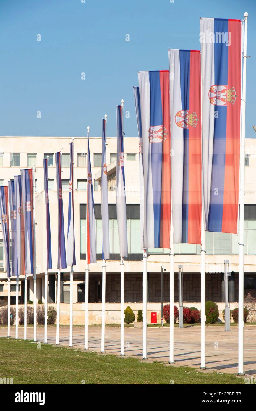 Belgrad, Serbien - 20. März 2020: Serbische Nationalflaggen auf Pfosten vor dem Palast von Serbien, einem Regierungsgebäude in New Belgrad Stockfoto