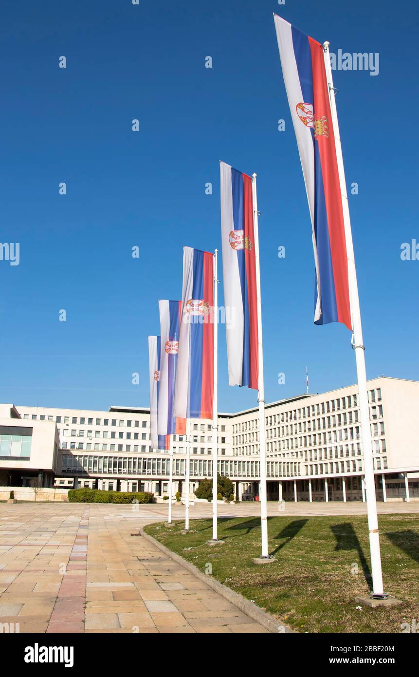Belgrad, Serbien - 20. März 2020: Serbische Nationalflaggen auf Pfosten vor dem Palast Serbiens, Regierungsgebäude 1951 fertiggestellt, die LARG Stockfoto