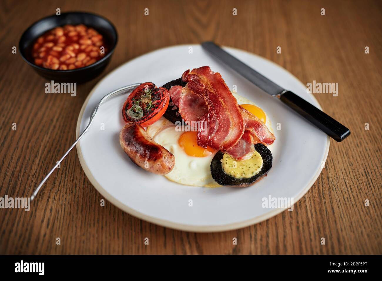 Frühstück braten bis komplette englische Wurst Ei Speck Pilz Bohnen Cafe fettiger Löffel Grill Stockfoto