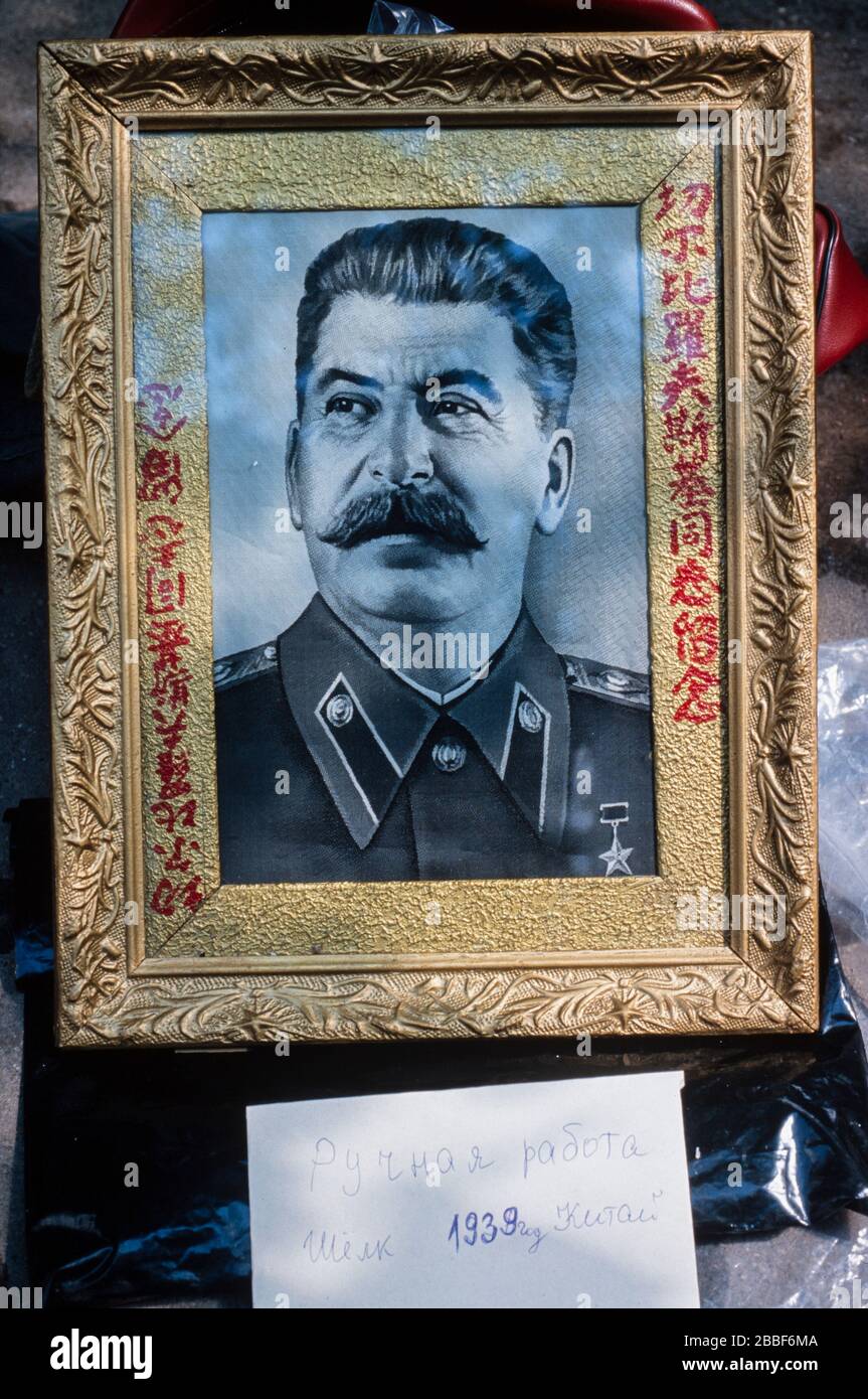 Hinweis unter dem gerahmten Porträt von Joseph Stalin, das auf einem Moskauer Flohmarkt zum Verkauf angeboten wird, heißt es: „Handgefertigte Kunstwerke auf Seide. 1939 China“. Stockfoto