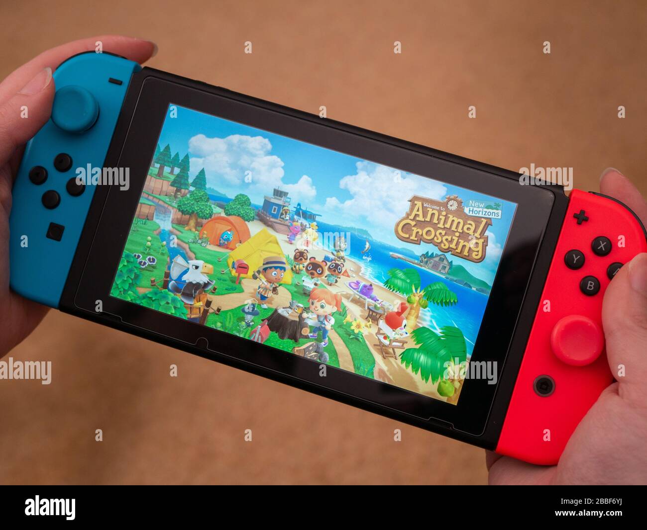 Großbritannien, März 2020: Nintendo Switch Spielekonsolen-Hand hielt das Spielen von Tieren über neue Horizonte Stockfoto