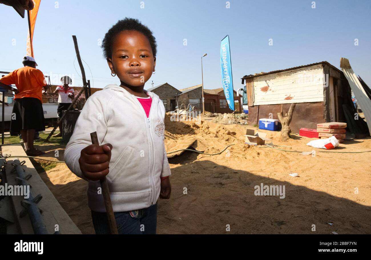Soweto, Südafrika - 11. September 2009: Little African Girl spielt auf dem Hinterhofgebäude in einer Soweto Township Stockfoto