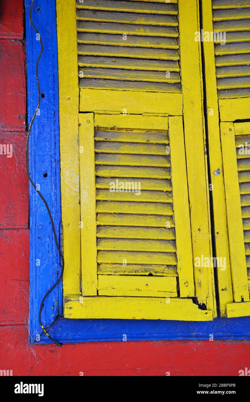 Buenos Aires, Argentina-Februar 2019: Nahansicht eines Fensterteils mit Blenden in Rot, Blau und Gelb am Haus im Viertel La Boca in Bueno Stockfoto