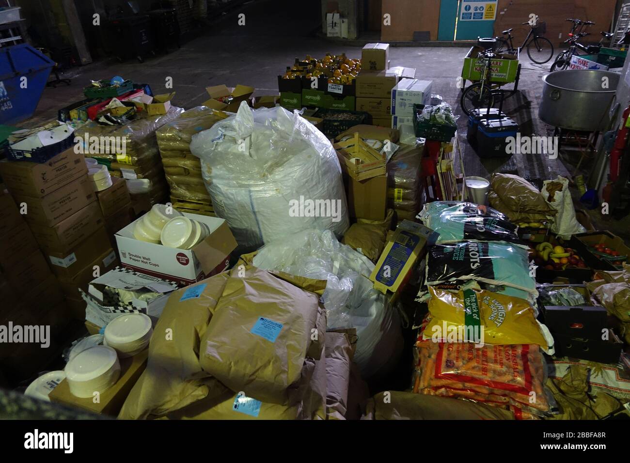 London, Großbritannien. März 2020. Freiwillige im Krishna Castle, Holborn, angeführt von Parasurama das, bereiten am selben Tag etwa 1000 Mahlzeiten für die Verteilung an Londons Obdachlose und verletzliche vor. Einer der Abschlagpunkte für vorgepackte Mahlzeiten ist ein Platz unterhalb des Tottenham Spurs Stadium, das als Lebensmittel-Drehscheibe genutzt wird, der ersten Community-Drehscheibe, die überschüssige Lebensmittel an die Londoner liefert. © Simon King/Alamy Live News Stockfoto