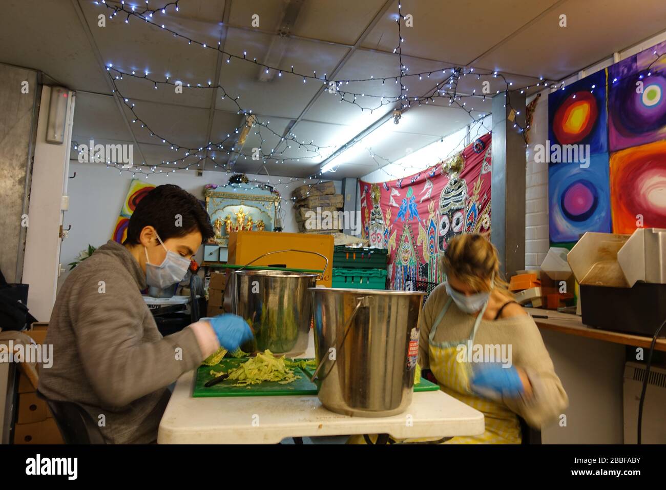 London, Großbritannien. März 2020. Freiwillige im Krishna Castle, Holborn, angeführt von Parasurama das, bereiten am selben Tag etwa 1000 Mahlzeiten für die Verteilung an Londons Obdachlose und verletzliche vor. Einer der Abschlagpunkte für vorgepackte Mahlzeiten ist ein Platz unterhalb des Tottenham Spurs Stadium, das als Lebensmittel-Drehscheibe genutzt wird, der ersten Community-Drehscheibe, die überschüssige Lebensmittel an die Londoner liefert. © Simon King/Alamy Live News Stockfoto