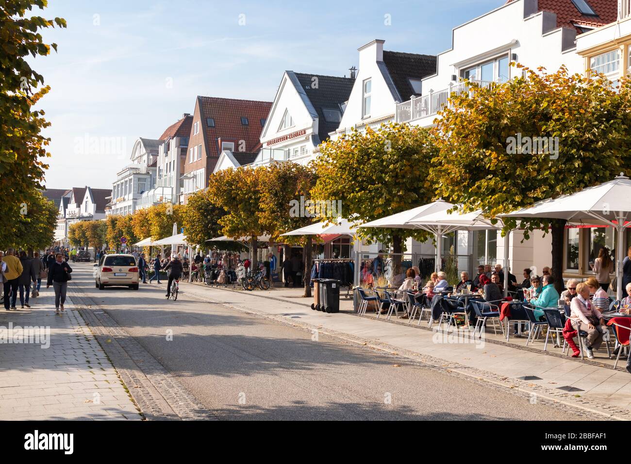 Lübeck-Travemünde, Deutschland - 10. Oktober 2018: Promenade mit vielen Cafés und historischer Architektur. Besucher sind Feriengäste und Tagesbesucher. Stockfoto