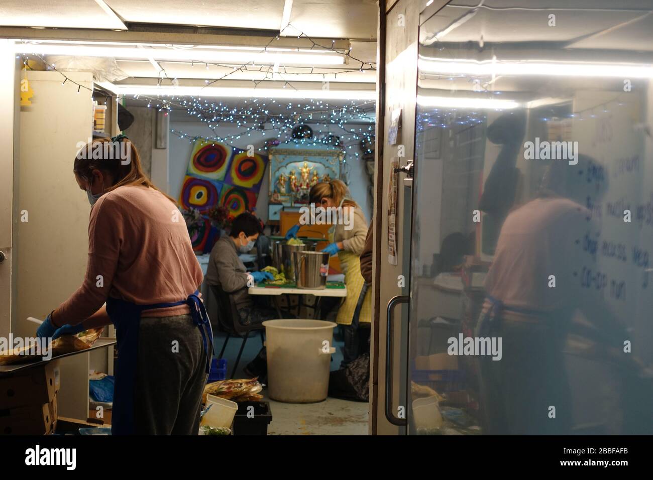 London, Großbritannien. März 2020. Freiwillige im Krishna Castle, Holborn, angeführt von Parasurama das, bereiten am selben Tag etwa 1000 Mahlzeiten für die Verteilung an Londons Obdachlose und verletzliche vor. Einer der Abschlagpunkte für vorgepackte Mahlzeiten ist ein Platz unterhalb des Tottenham Spurs Stadium, das als Lebensmittel-Drehscheibe genutzt wird, der ersten Community-Drehscheibe, die überschüssige Lebensmittel an die Londoner liefert. © Simon King/Alamy Live News Stockfoto