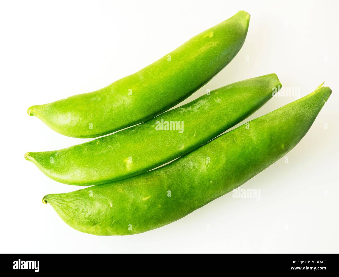 Drei frische grüne Zuckererbsen auf weißem Hintergrund Stockfoto