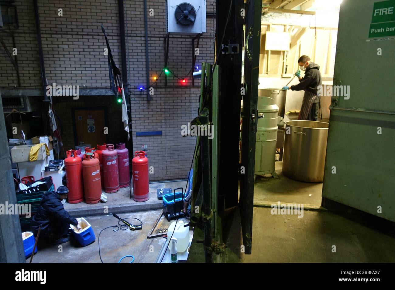 London, Großbritannien. März 2020. Freiwillige im Krishna Castle, Holborn, angeführt von Parasurama das, bereiten am selben Tag etwa 1000 Mahlzeiten für die Verteilung an Londons Obdachlose und verletzliche vor. Einer der Abschlagpunkte für vorgepackte Mahlzeiten ist ein Platz unterhalb des Tottenham Spurs Stadium, das als Lebensmittel-Drehscheibe genutzt wird, der ersten Community-Drehscheibe, die überschüssige Lebensmittel an die Londoner liefert. © Simon King/Alamy Live News Stockfoto