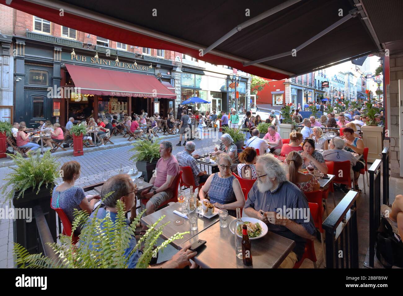 Restaurants und Pubs übernehmen die Bürgersteige an der Rue Saint-Jean (St. John St.) zu einem Zeitpunkt, zu dem es für den Fahrzeugverkehr gesperrt ist, Oberstadt, Quebec City, Provinz Quebec, Kanada. Stockfoto