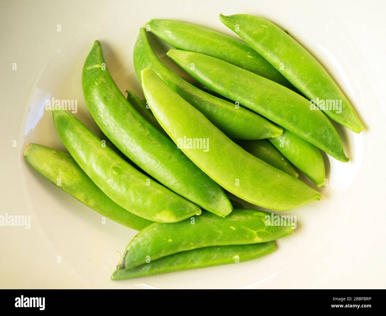 Portion frischer grüner Zuckererbsen in einer Schüssel Stockfoto