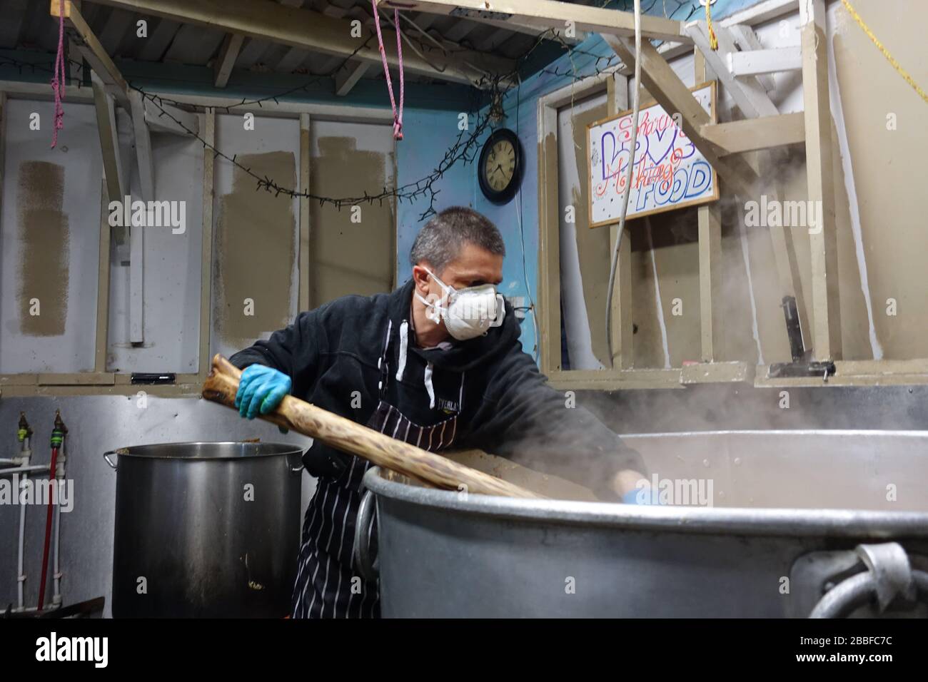 London, Großbritannien. März 2020. Freiwillige im Krishna Castle, Holborn, angeführt von Parasurama das, bereiten am selben Tag etwa 1000 Mahlzeiten für die Verteilung an Londons Obdachlose und verletzliche vor. Einer der Abschlagpunkte für vorgepackte Mahlzeiten ist ein Platz unterhalb des Tottenham Spurs Stadium, das als Lebensmittel-Drehscheibe genutzt wird, der ersten Community-Drehscheibe, die überschüssige Lebensmittel an die Londoner liefert. © Simon King/Alamy Live News Stockfoto