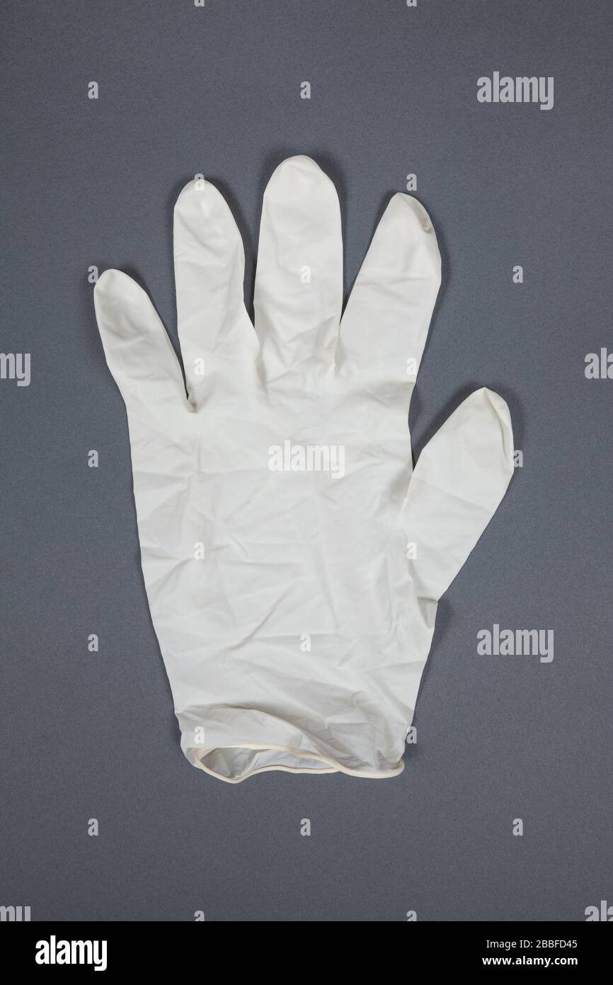 Medizinischer Handschuh auf grauem Hintergrund Stockfoto