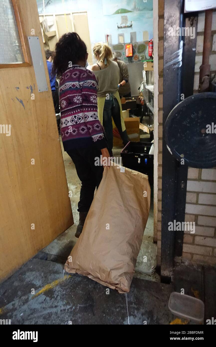 London, Großbritannien. März 2020. Freiwillige im Krishna Castle, Holborn, angeführt von Parasurama das, bereiten am selben Tag etwa 1000 Mahlzeiten für die Verteilung an Londons Obdachlose und verletzliche vor. Einer der Abschlagpunkte für vorgepackte Mahlzeiten ist ein Platz unterhalb des Tottenham Spurs Stadium, das als Lebensmittel-Drehscheibe genutzt wird, der ersten Community-Drehscheibe, die überschüssige Lebensmittel an die Londoner liefert. © Simon King/Alamy Live News Stockfoto