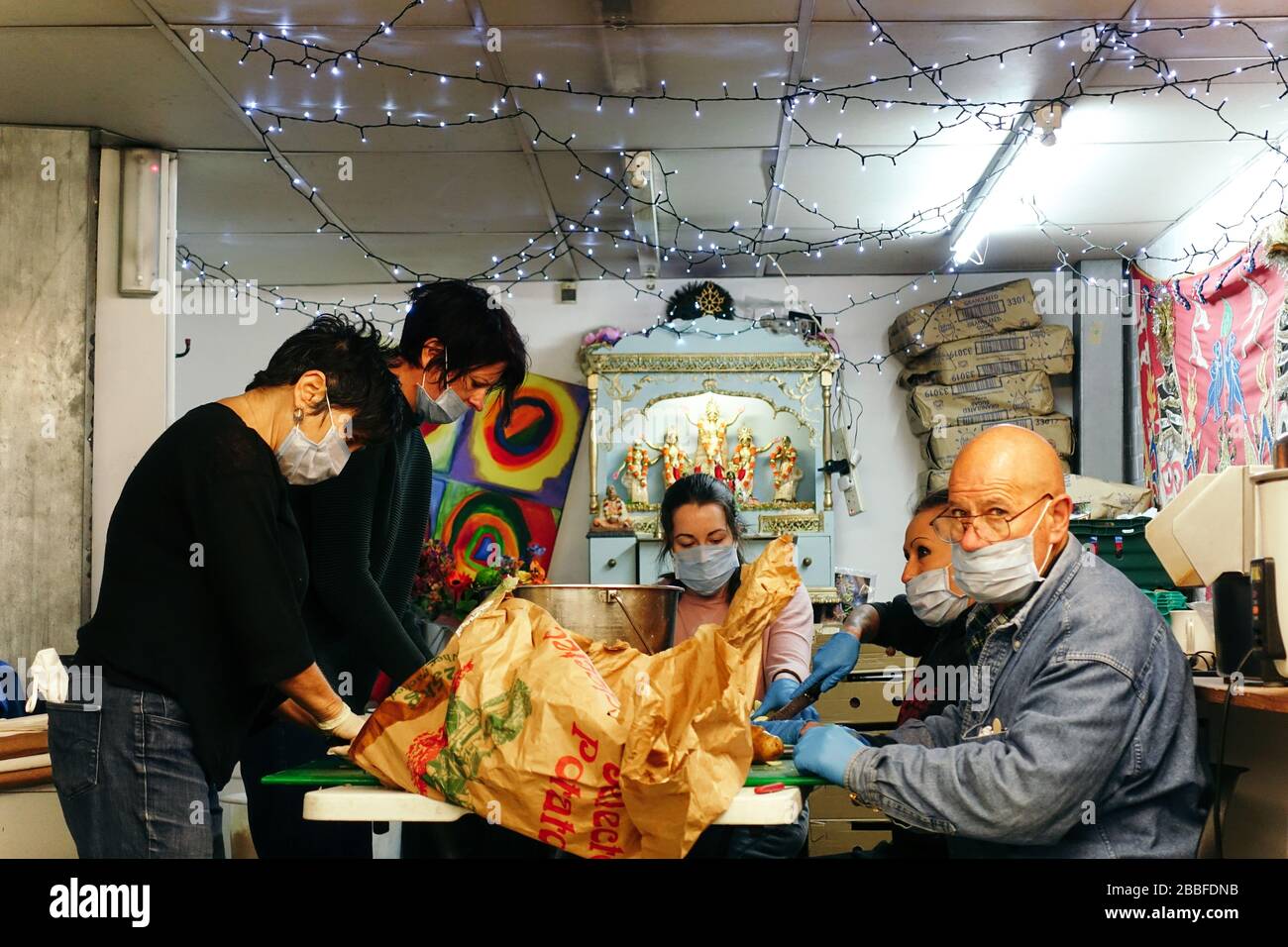 London, Großbritannien. März 2020. Freiwillige im Krishna Castle, Holborn, angeführt von Parasurama das, bereiten am selben Tag etwa 1000 Mahlzeiten für die Verteilung an Londons Obdachlose und verletzliche vor. Einer der Abschlagpunkte für vorgepackte Mahlzeiten ist ein Platz unterhalb des Tottenham Spurs Stadium, das als Lebensmittel-Drehscheibe genutzt wird, der ersten Community-Drehscheibe, die überschüssige Lebensmittel an die Londoner liefert. © Simon King/Alamy Live News Stockfoto