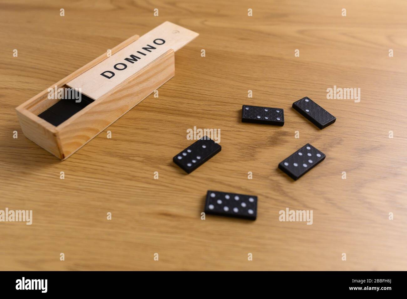 domino setzte schwarz mit Kacheln in Holzkiste auf Holzhintergrund Stockfoto