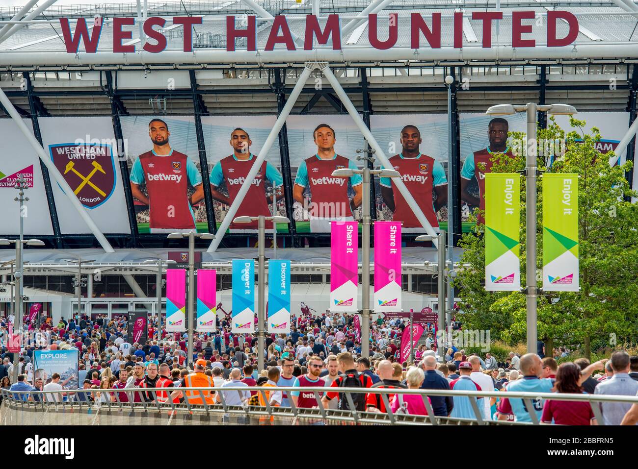 Bunte Menschenmassen von Fußballfans gehen in das Londoner Stadion, das die Heimat des West Ham United Football Club im Olympic Park East London ist. Stockfoto