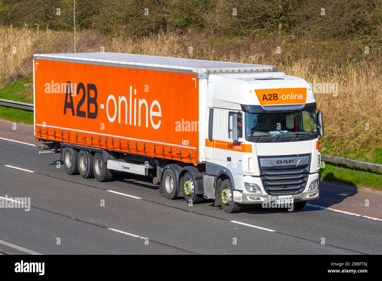 A2B-ONLINE-TRANSPORTFAHRZEUGE, orangefarbene Lastkraftwagen, Transport, LKW, Frachtführer, DAF XF-Fahrzeug, europäischer kommerzieller Transport, Industrie, M61 in Manchester, Großbritannien Stockfoto