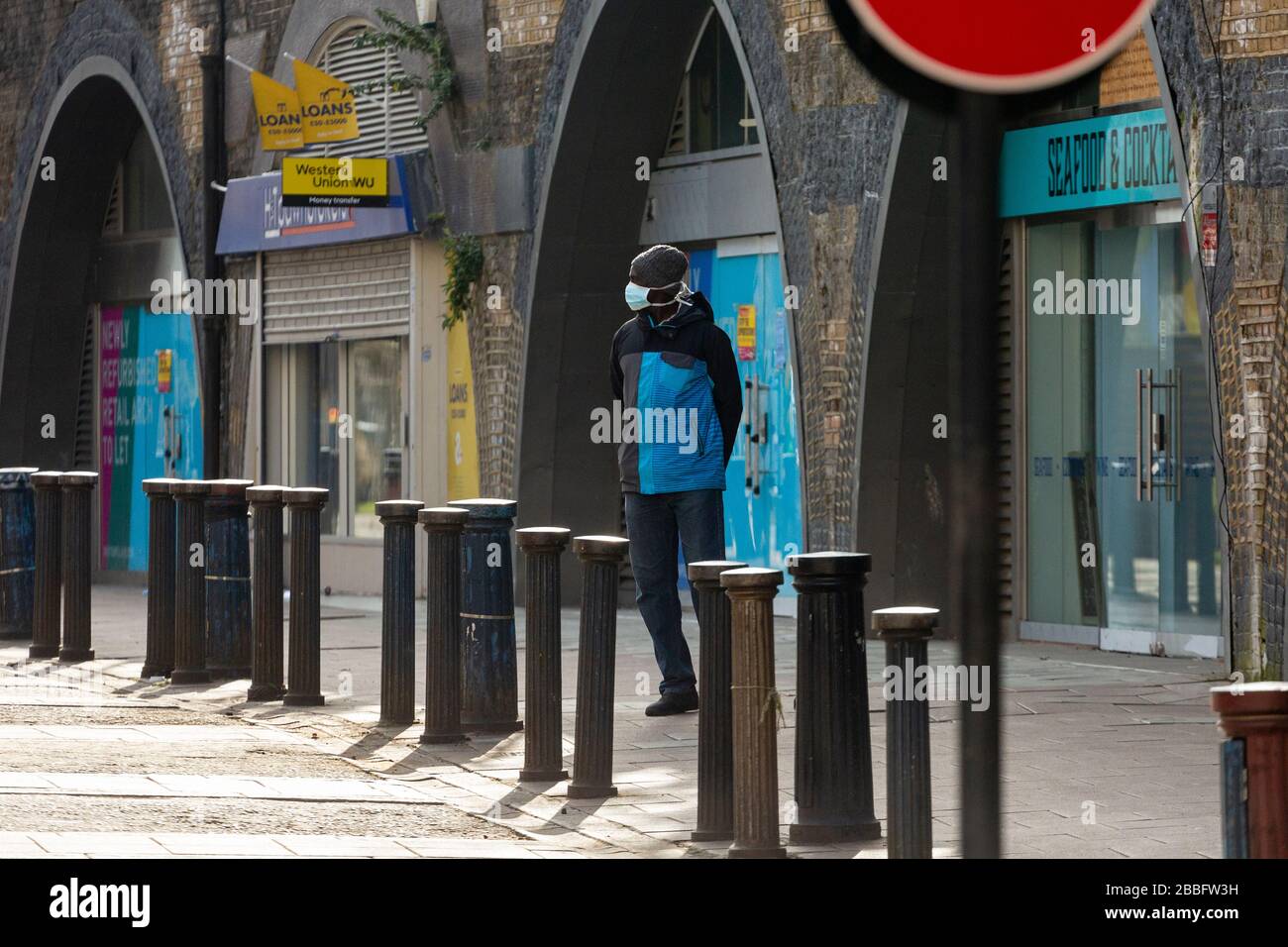 Mann, der eine Schutzmaske auf der Brixton Station Road trägt, während der Londoner Sperrung aufgrund der Ausbreitung von Covid-19. Am 31. März 2020 aufgenommen Stockfoto