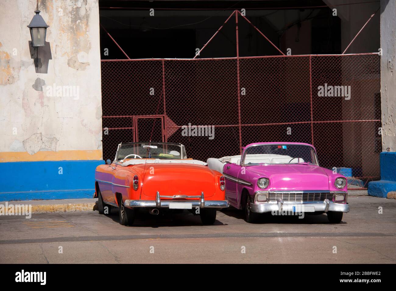 HAVANNA, KUBA - 30. MÄRZ 2017: Zwei konvertible amerikanische Oldtimer aus den 60er Jahren parkten am Eingang einer Garage in der Stadt Havanna, Kuba. Stockfoto