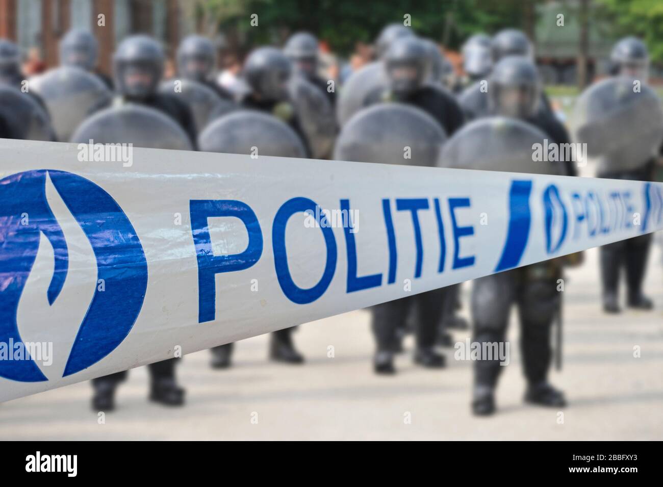 Polite/Polizeiband vor der belgischen Bereitschaftstruppe, die in Belgien eine Schutzbarriere mit Bereitschaftssiegen bildet Stockfoto