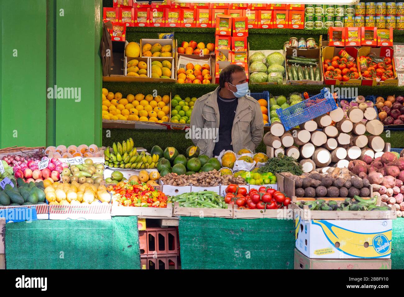 Anbieter, der während der Londoner Sperrung aufgrund der Verbreitung von Covid-19 eine Schutzmaske an der Electric Avenue in Brixton trägt. Am 31. März 2020 aufgenommen Stockfoto