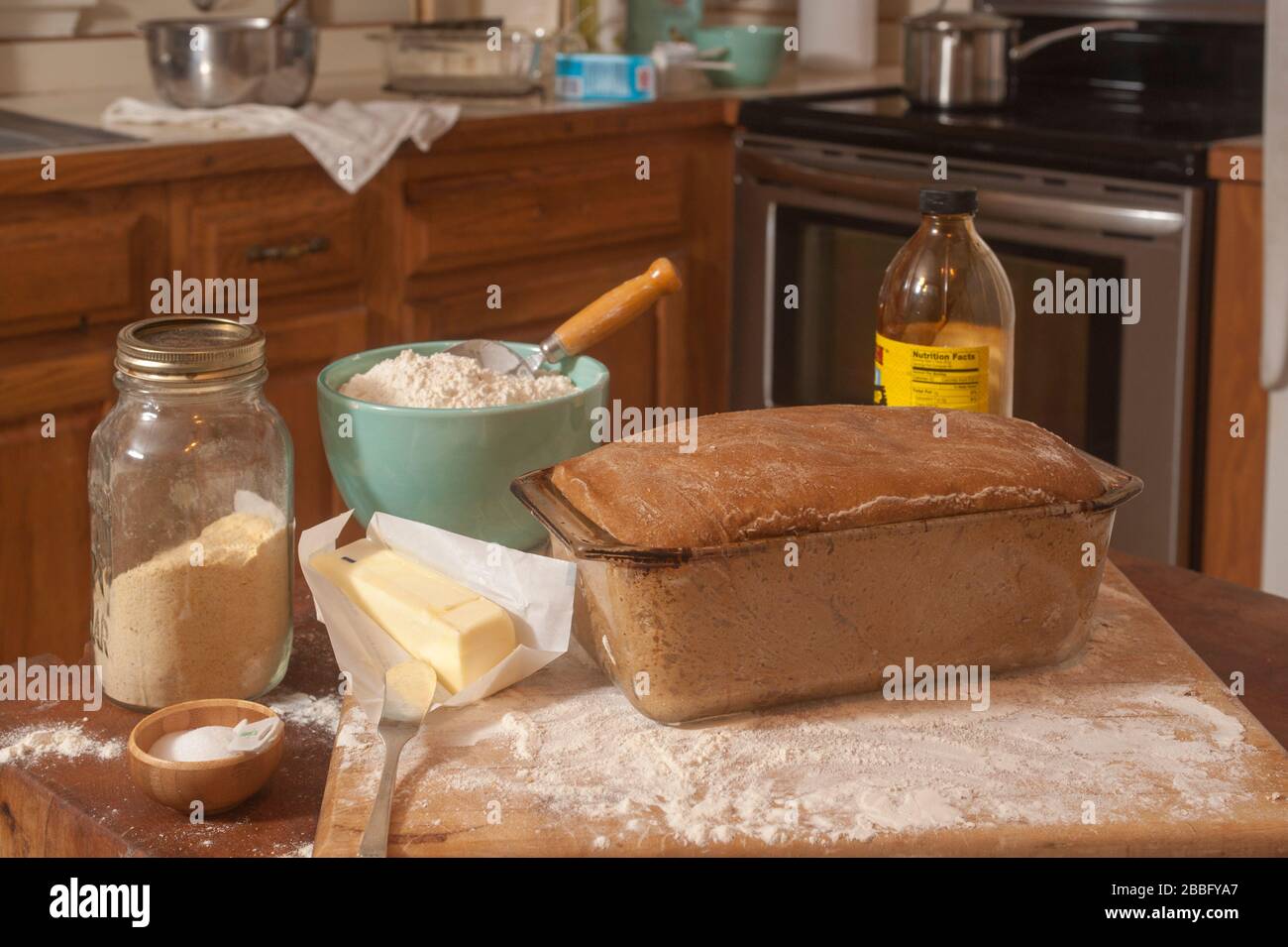 Anadama Brot in Glasplatte bereit für den Ofen und Zutaten auf Metzgerblock und Counter Top in der Küche. Stockfoto