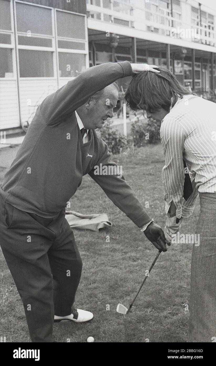 1970s, ein Golfprofi, der einem jungen Mann eine Lektion erteilt, England, Großbritannien. Stockfoto