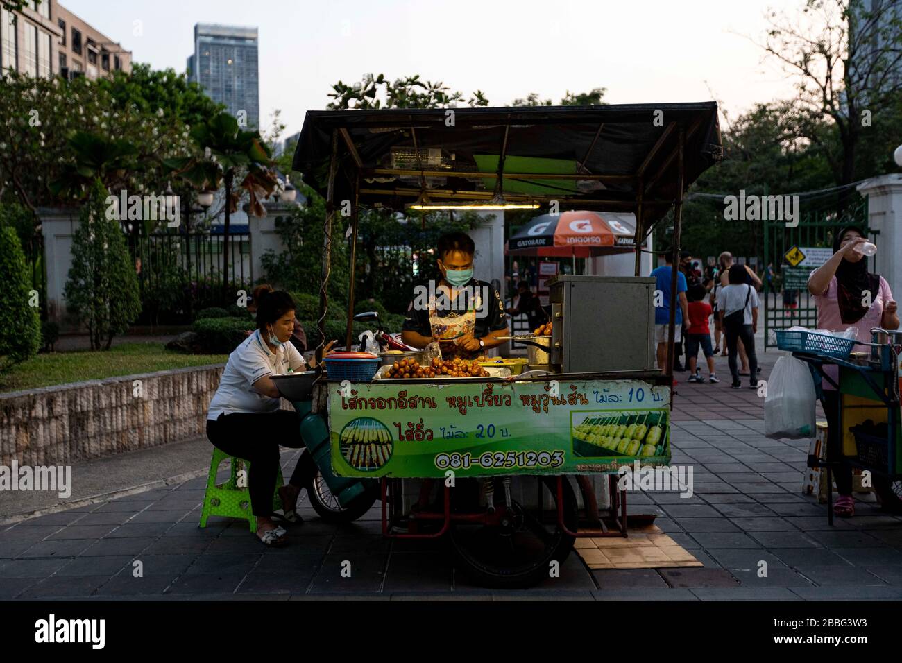 Bangkok, Bangkok, Thailand. März 2020. Ein Straßenhändler verkauft traditionelle Thai-Wurst vor dem Park Benjamin-asiri. Die Bürger Bangkoks leben seit dem 26. März unter einer teilweisen Sperrung der Stadt, da die tägliche Anzahl der bestätigten Covid-19-Fälle stetig zugenommen hat. Soziale Distanzierung und Selbstisolation wurden von den Behörden gefördert, obwohl es aufgrund der täglichen Verpflichtungen, die viele Menschen haben, oft schwierig ist, diese beizubehalten. Credit: Adryel Talamantes/ZUMA Wire/Alamy Live News Stockfoto