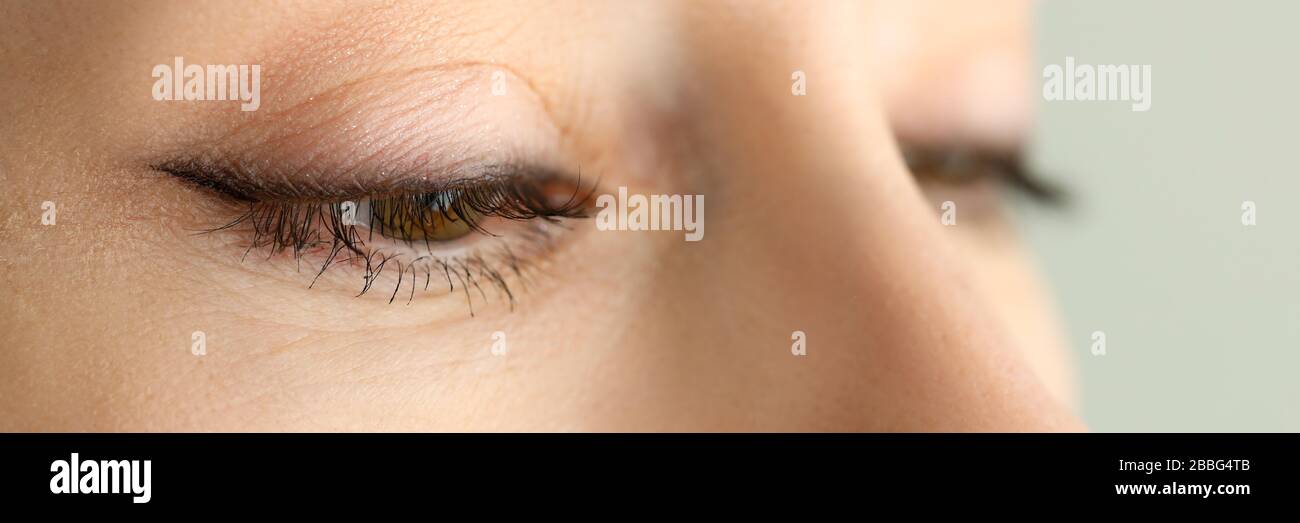 Orange-grün-farbige weibliche, erstaunliche halbgeöffnete Augen Stockfoto