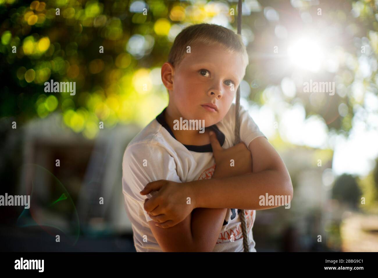 Portrait eines jungen Jungen, der auf einer Seilschwinge spielt Stockfoto