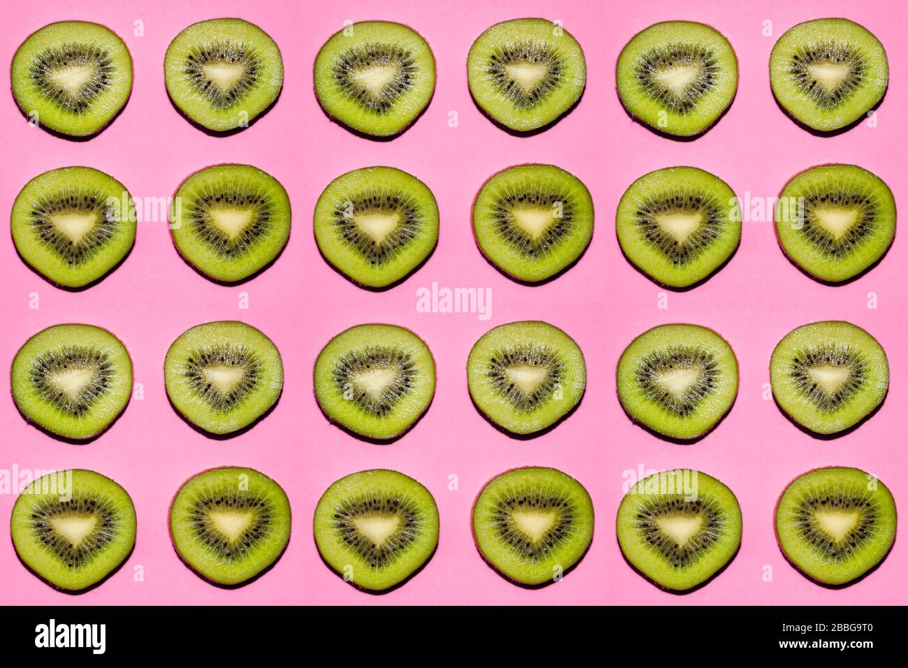 Fruchtmuster. Scheiben Kiwifrucht auf pinkfarbenem Hintergrund Stockfoto