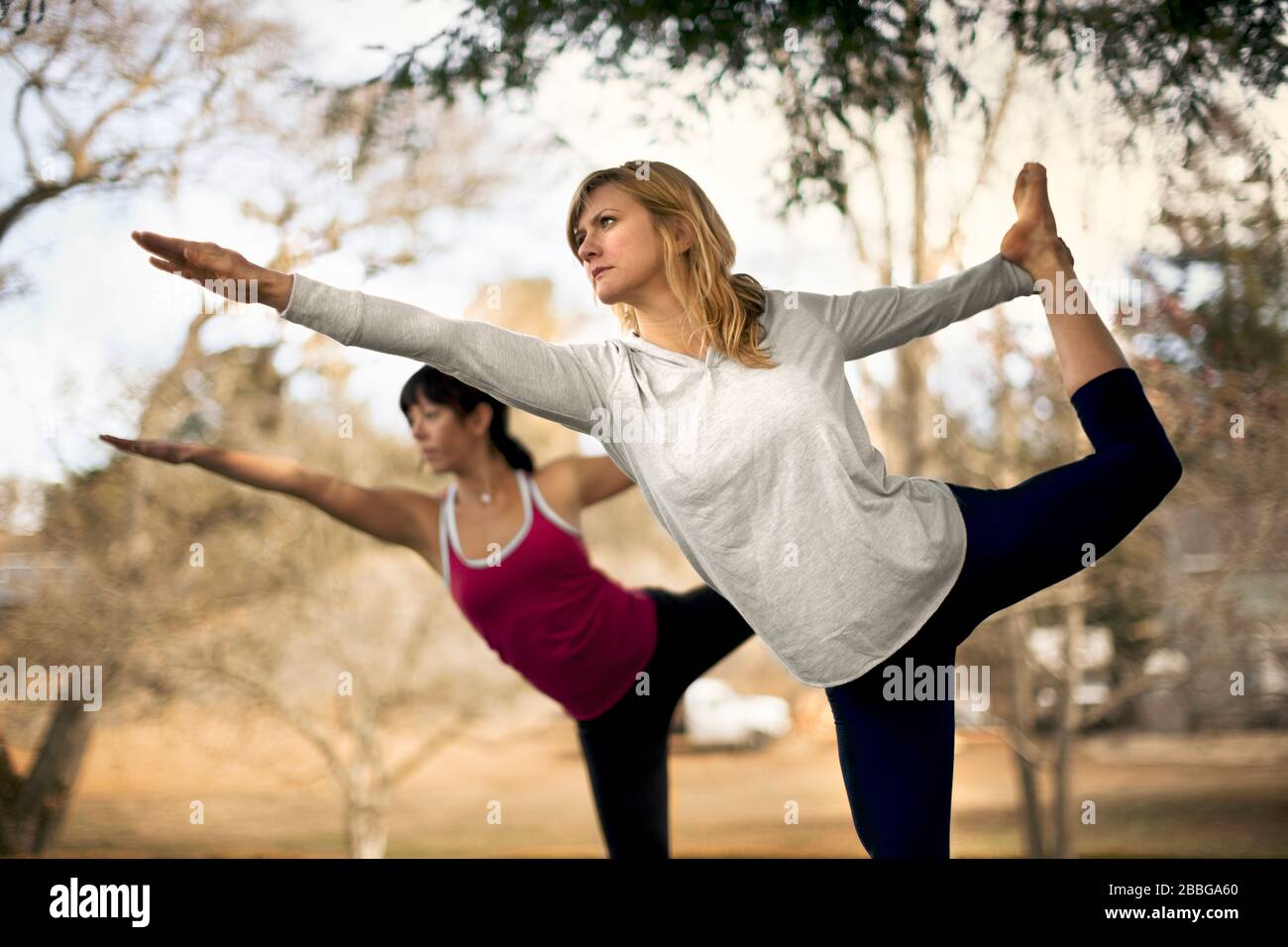 Zwei Frauen praktizieren Yoga-Posen im Park Stockfoto