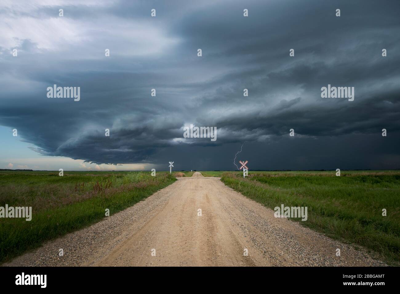 Sturm mit Blitzschlag am Ende einer ländlichen Schotterstraße im Süden Manitobas Kanadas Stockfoto