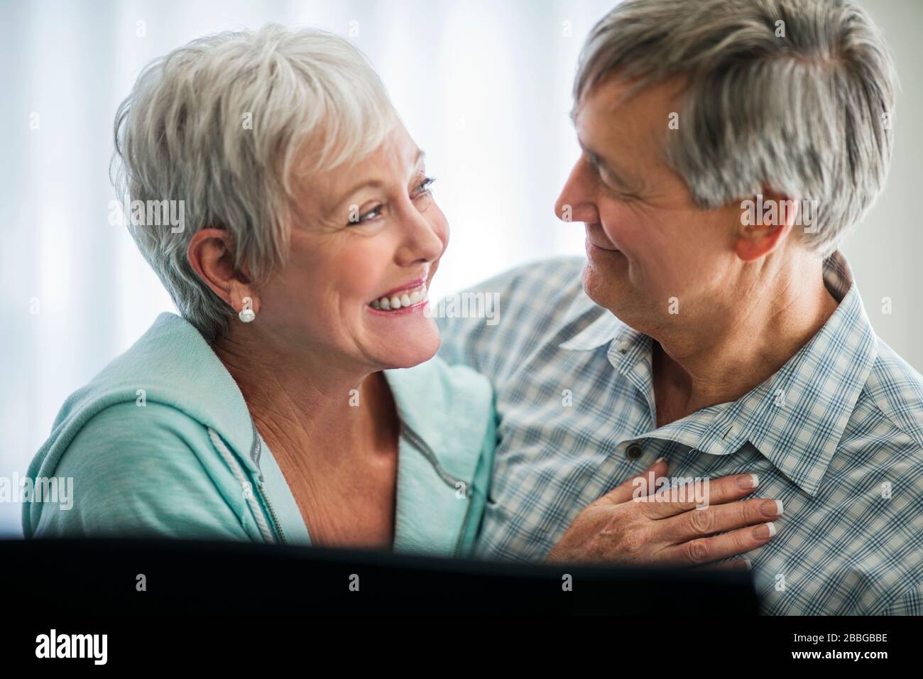 Liebevoll reifes Paar lächelt, während sie in die Augen des anderen blicken Stockfoto