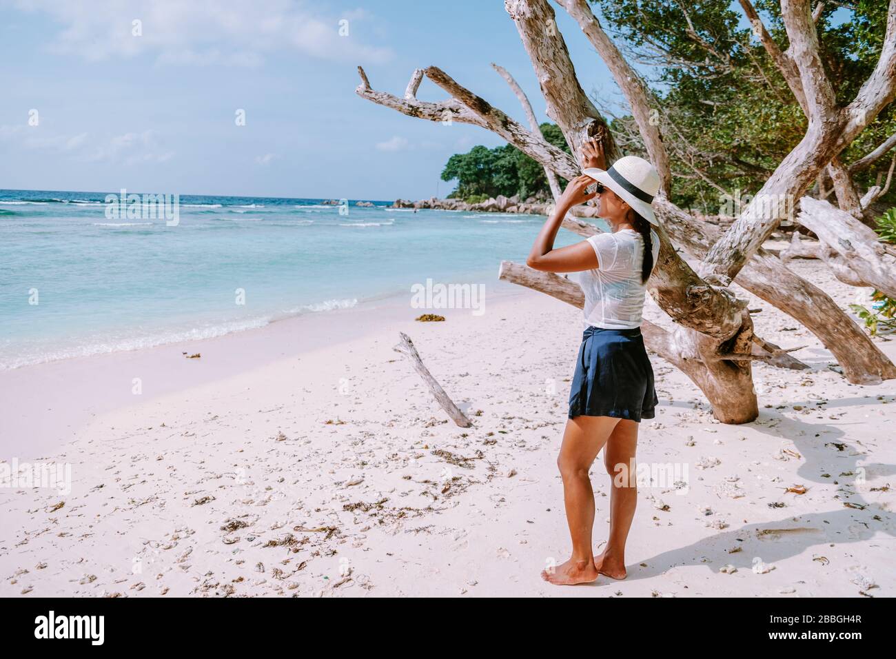 Petite Anse Mahe Seychellen, junge Frau am Strand, mittelalte Asiatin, die am tropischen Strand der Seychellen spaziert Stockfoto