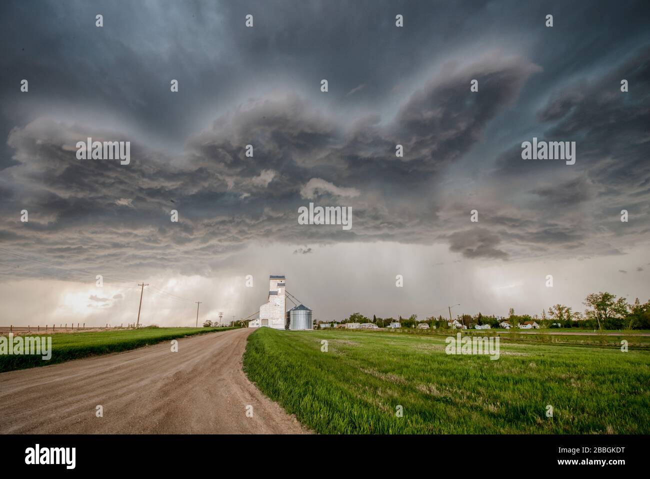 Sturm mit Schotterstraße über Körnerei im ländlichen Süden Manitobas Kanadas Stockfoto