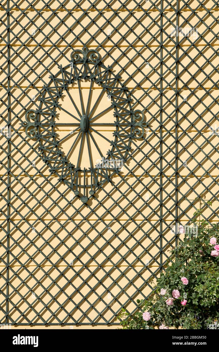 Holzgitter an gelber Fassade des Biedermeier Schlosses mit Fenstern und grünen Fensterläden, Schloss Kogl, Oberösterreich Stockfoto