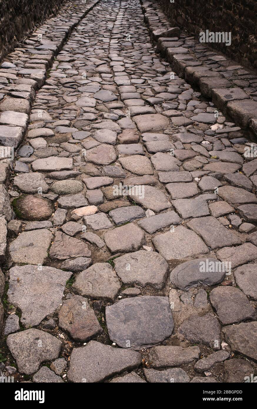 Gepflasterer Vintage-Weg in Perspektive. Gepflasterte Steinstraße in einem kleinen Winkel dargestellt. Pflaster in Perspektive. Stockfoto