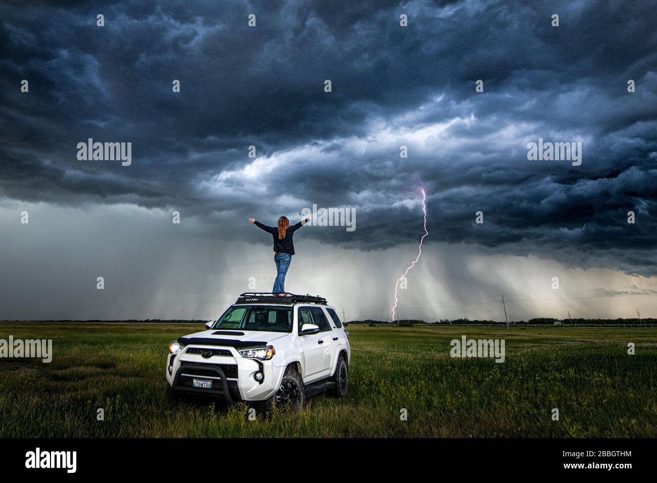 Selbstporträt auf meinem LKW mit Sturm und Blitz in der Ferne im ländlichen Manitoba Kanada Stockfoto