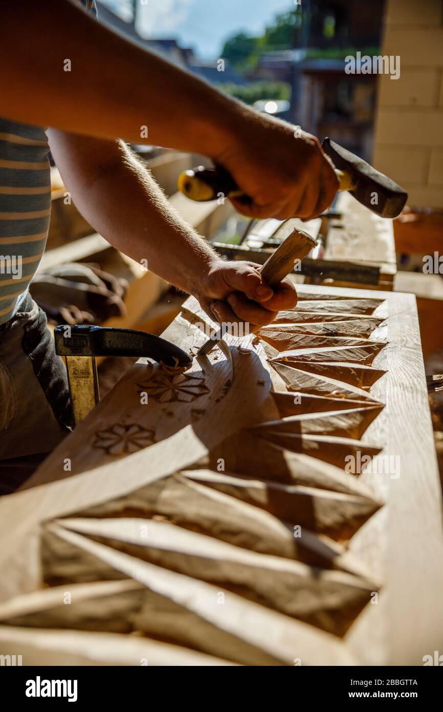 Man schnitzt in der Holzschnitzwerkstatt traditionelle Motive aus Maramures Rumänien in Holz Stockfoto